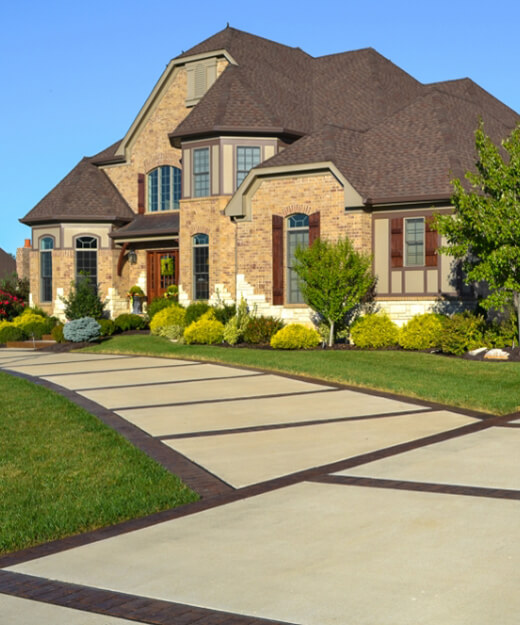 A custom brick home with stylized concrete walkway